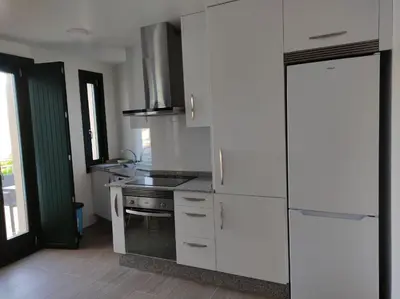 a kitchen with a white refrigerator and a stove at Apartamento Salvadas in Santiago de Compostela