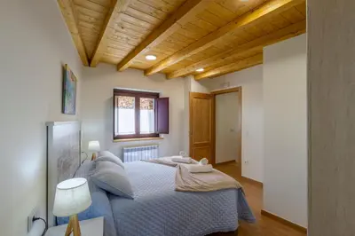a bedroom with two beds and a wooden ceiling at Casa Añolo in Sober