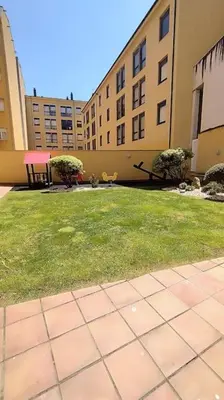 a grassy yard with buildings in the background at Apartamento en Foz. Primera Línea Playa Rapadoira in Foz