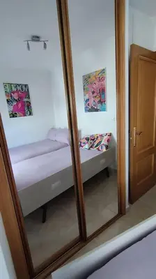 a reflection of a bedroom with a bed in a mirror at Apartamento en Foz. Primera Línea Playa Rapadoira in Foz