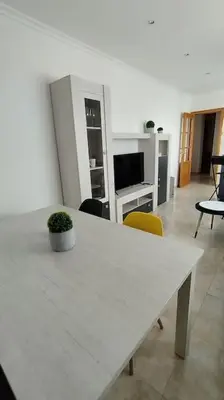 a white table with a potted plant on it in a living room at Apartamento en Foz. Primera Línea Playa Rapadoira in Foz