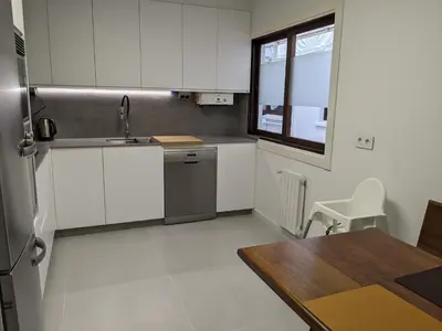 a kitchen with white cabinets and a table and a window at Mirador de Ferradores in Betanzos
