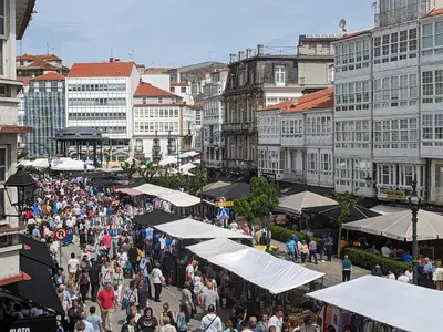 a crowd of people walking around a market with white tents at Mirador de Ferradores in Betanzos