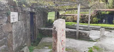 a stone pillar in front of a stone wall at Mirador de Ferradores in Betanzos