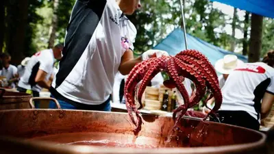 a man holding a red octopus in a pot at Cánovas 21 in Carballino