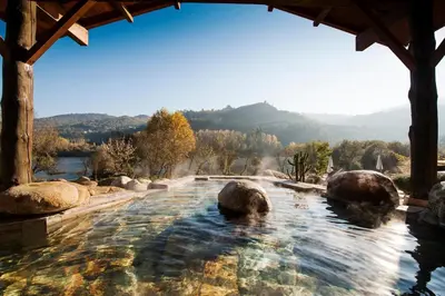 a swimming pool with rocks in the water at Cánovas 21 in Carballino
