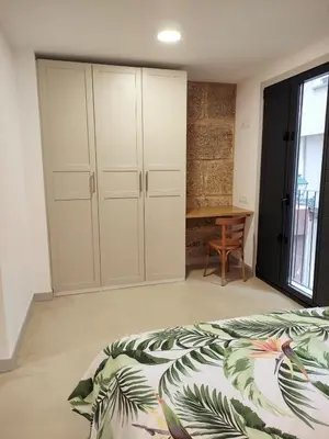 a bedroom with a bed and a desk and a table at Cánovas 21 in Carballino