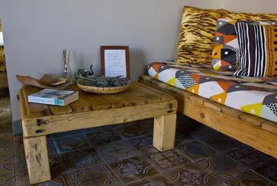 a room with a bed with a wooden table with a table at Pension Gabino (rooms) in El Ganso