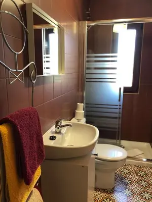 a bathroom with a sink and a toilet and a mirror at Pension Gabino (rooms) in El Ganso
