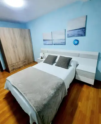 a bedroom with a large white bed with two pillows at Apartamento Obao in Ribadeo