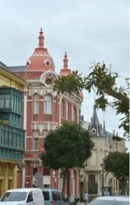 a large red brick building with a tree in front of it at Apartamento Obao in Ribadeo