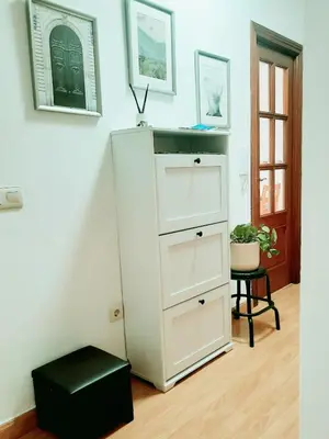 a white dresser with a black stool in a room at Apartamento Obao in Ribadeo