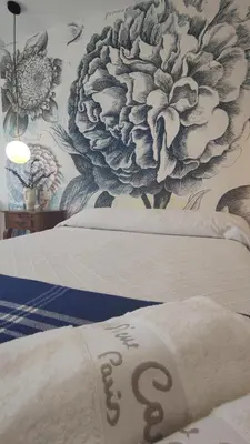 a bedroom with two beds with a floral wallpaper at Suite Playa in Miño