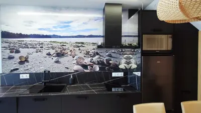 a kitchen with a large picture of people on the beach at Suite Playa in Miño
