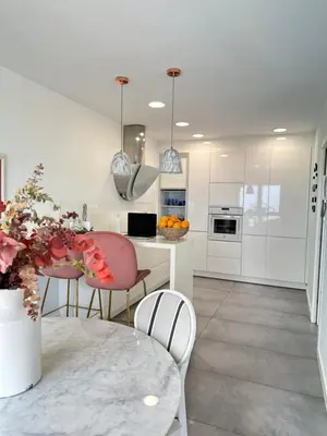 a white kitchen with a table and chairs at DÚPLEX DE LUJO EN FOZ CON VISTAS al MAR in Foz