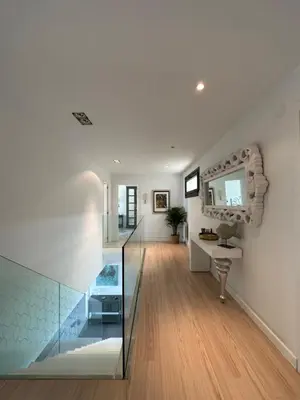 a hallway with a glass staircase and a mirror at DÚPLEX DE LUJO EN FOZ CON VISTAS al MAR in Foz