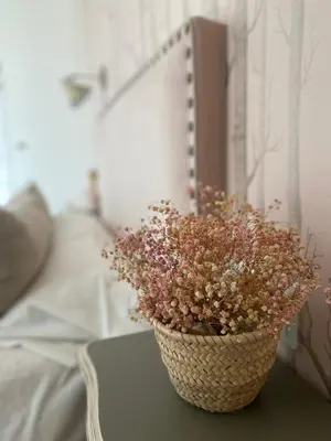 a basket of flowers sitting on a table next to a bed at DÚPLEX DE LUJO EN FOZ CON VISTAS al MAR in Foz