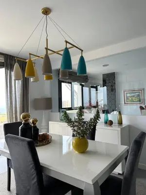a kitchen and dining room with a white table and chairs at DÚPLEX DE LUJO EN FOZ CON VISTAS al MAR in Foz