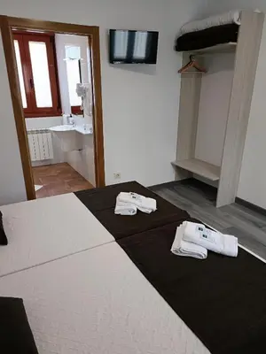 a bedroom with a bed with two towels on it at Albergue Miraiso in Arzúa