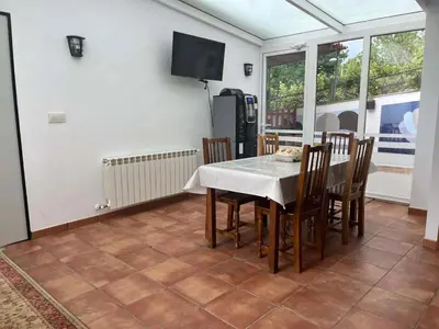 a dining room with a white table and chairs at Albergue Miraiso in Arzúa
