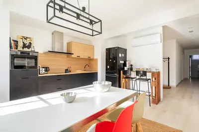 a large kitchen with a white counter top and red chairs at Iria Gardens in Padrón
