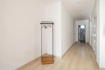 a hallway with a mirror in a white room at Iria Gardens in Padrón