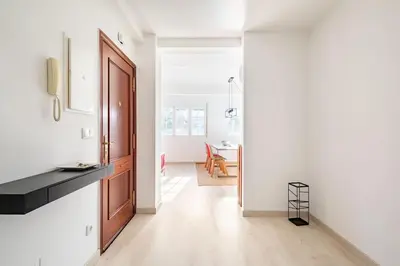 a kitchen with white walls and a wooden door at Iria Gardens in Padrón