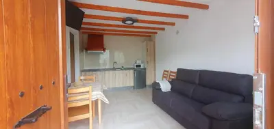 a living room with a couch and a kitchen at ALOJAMIENTOS EL CASTRO in Taramundi