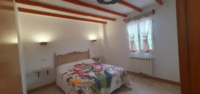 a small bedroom with a bed and a window at ALOJAMIENTOS EL CASTRO in Taramundi