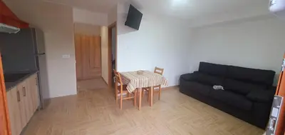 a living room with a black couch and a table at ALOJAMIENTOS EL CASTRO in Taramundi