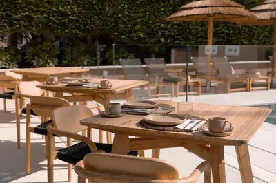 a wooden table and chairs with cups and plates on it at Malates Slow Boutique Hotel in Foz