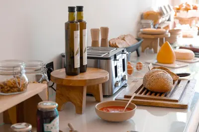 a kitchen with a counter top with bread and bottles at Malates Slow Boutique Hotel in Foz