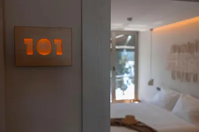 an orange clock on a wall next to a bed at Malates Slow Boutique Hotel in Foz