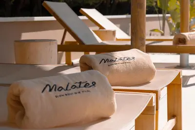 two folded towels on a table with chairs at Malates Slow Boutique Hotel in Foz