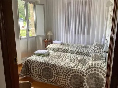 a bedroom with two beds and a window at VIVEIRO.CELEIRO. CASA TRANQUILA. RESURRECTION FEST in Cillero