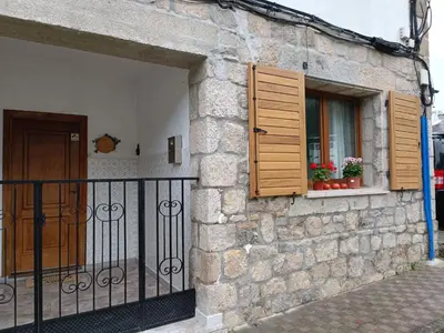 a stone building with a window with wooden shutters at VIVEIRO.CELEIRO. CASA TRANQUILA. RESURRECTION FEST in Cillero