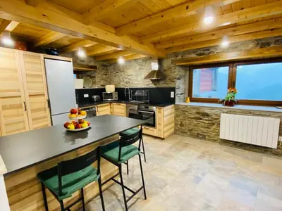 a kitchen with a table and chairs in a room at Casa Neto Goje in San Tirso de Abres