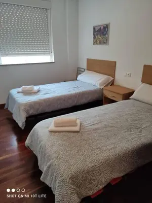 two beds in a room with two towels on them at Precioso apartamento, Pontedeume in Puentedeume
