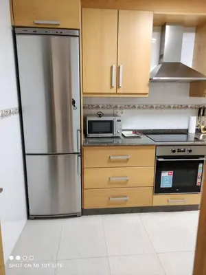 a kitchen with a stainless steel refrigerator and a microwave at Precioso apartamento, Pontedeume in Puentedeume