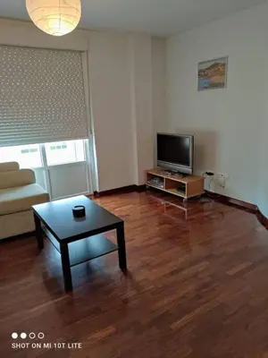 a living room with a coffee table and a tv at Precioso apartamento, Pontedeume in Puentedeume