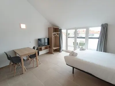 a bedroom with a bed and a desk and a table at Apartamentos Turísticos Pontepedriña by Bossh! Hotels in Santiago de Compostela