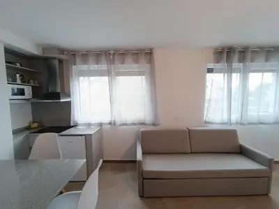 a living room with a couch and two windows at Apartamentos Turísticos Pontepedriña by Bossh! Hotels in Santiago de Compostela