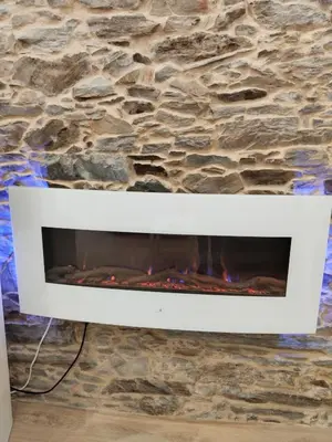 a white fireplace with a stone wall at TraviesaBetanzos in Betanzos