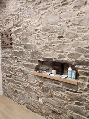 a stone wall with a shelf in front of it at TraviesaBetanzos in Betanzos