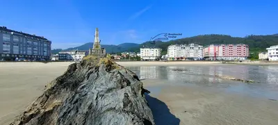a large rock in the sand on a beach at Alojamientos Viveiro - Playa de Covas II in Viveiro