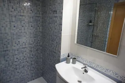 a bathroom with a sink and a mirror at Alojamientos Viveiro - Playa de Covas II in Viveiro