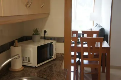 a kitchen with a microwave on a counter next to a table at Alojamientos Viveiro - Playa de Covas II in Viveiro