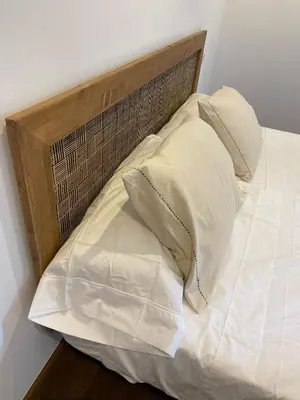a bed with a wooden headboard and three pillows at Apartamento foroplaza campo I in Lugo