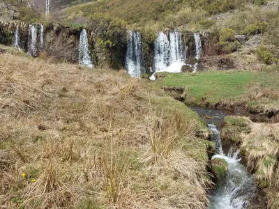 a waterfall in the middle of a grassy field at VUT Corea324 in Caboalles de Abajo