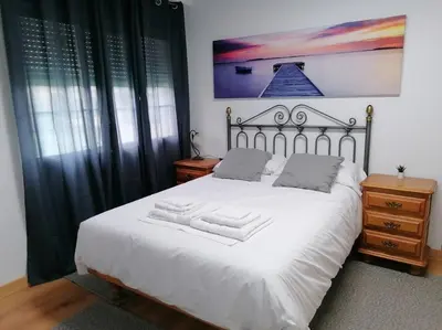 a bedroom with a white bed with two towels on it at Lar de Yago - Apto Ribadeo in Ribadeo